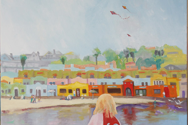 water, sand, toy buckets, shovel, child wrapped in colorful towel, colorful Capitola Village in background